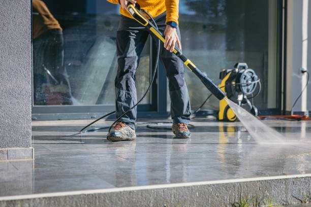 Technician from Laddermen Home Services washing a residential driveway