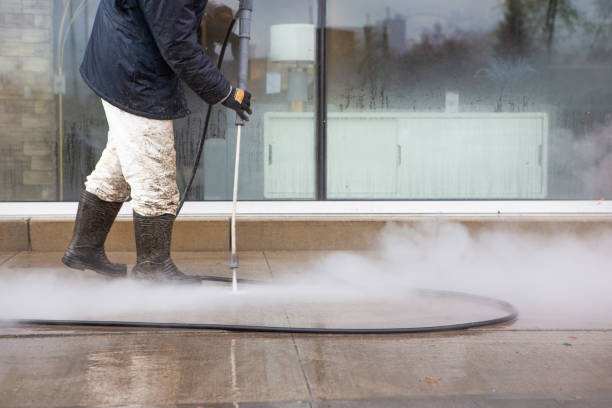 Technician pressure washing driveway in Olalla, WA neighborhood