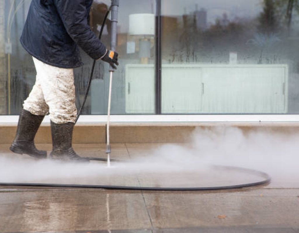 Technician pressure washing driveway in Olalla, WA neighborhood